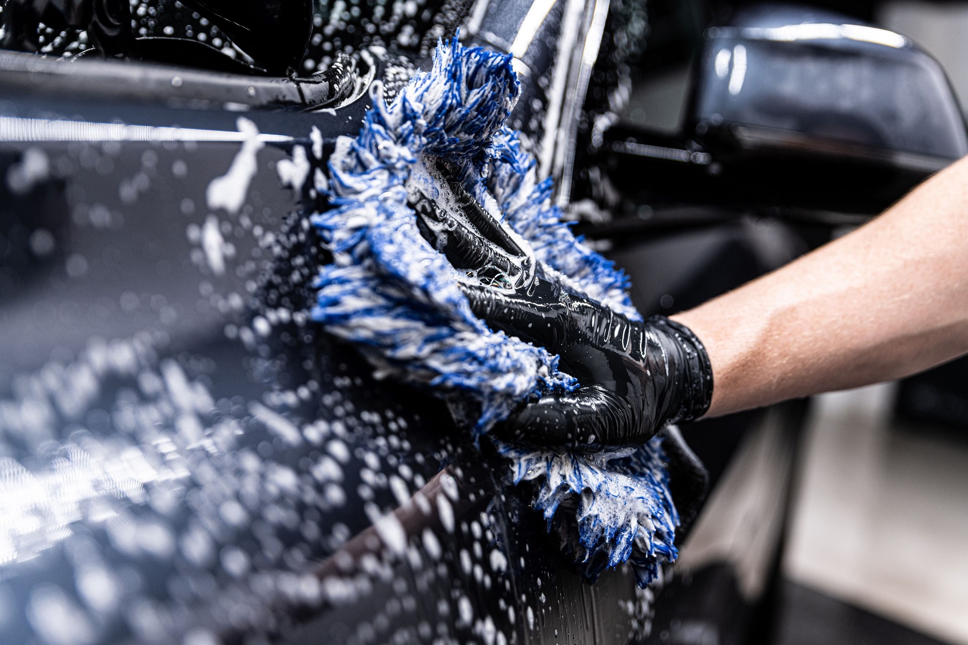 car wash employee thoroughly washes a modern car